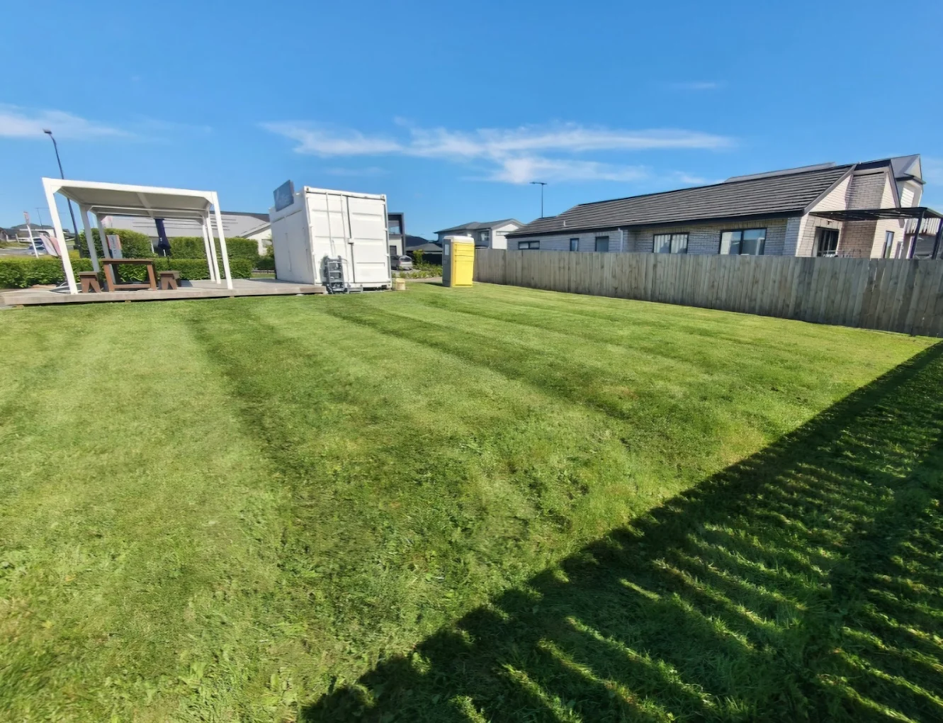 Freshly striped lawn running to a timber fence after a Ground Effects visit