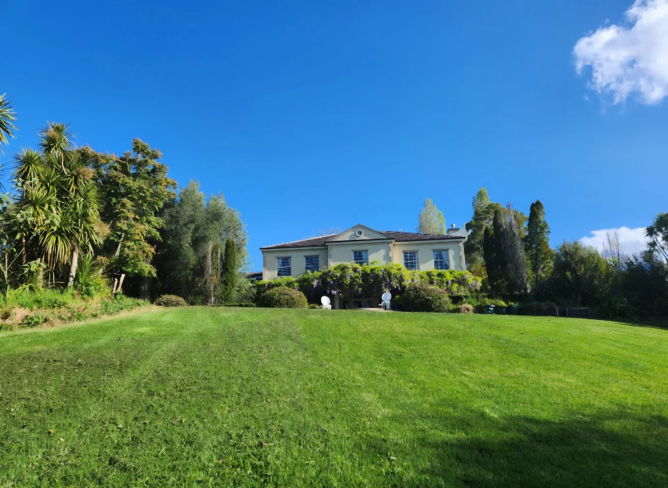 Wide freshly mown lawn in front of a country villa
